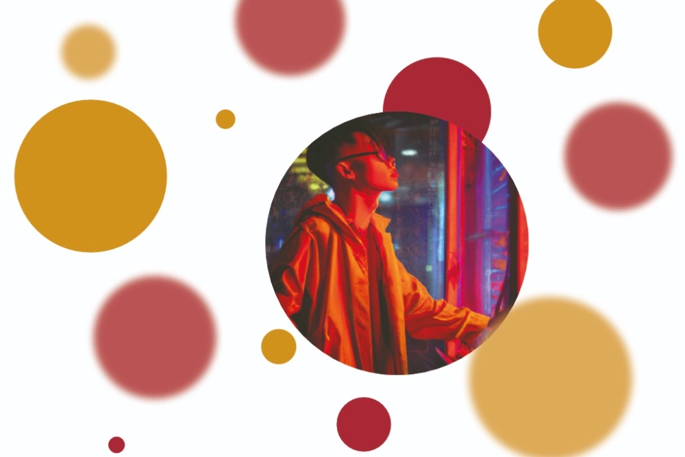 FiANTEC Informatikpreis: Kreisförmiger Ausschnitt eines Bildes eines Schüler, der vor Servern in rot-blauem Licht steht, um das Bild herum befinden sich gelbe und rote Kreise, teilweise mit Unschärfe-Effekt.