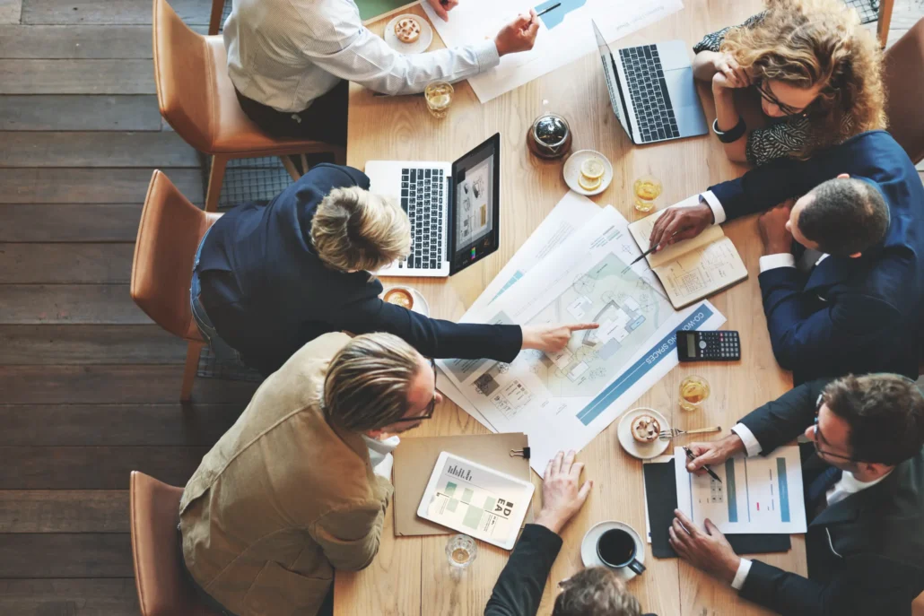 Geschäftspartner sitzen an einem Tisch und diskutieren über Pläne