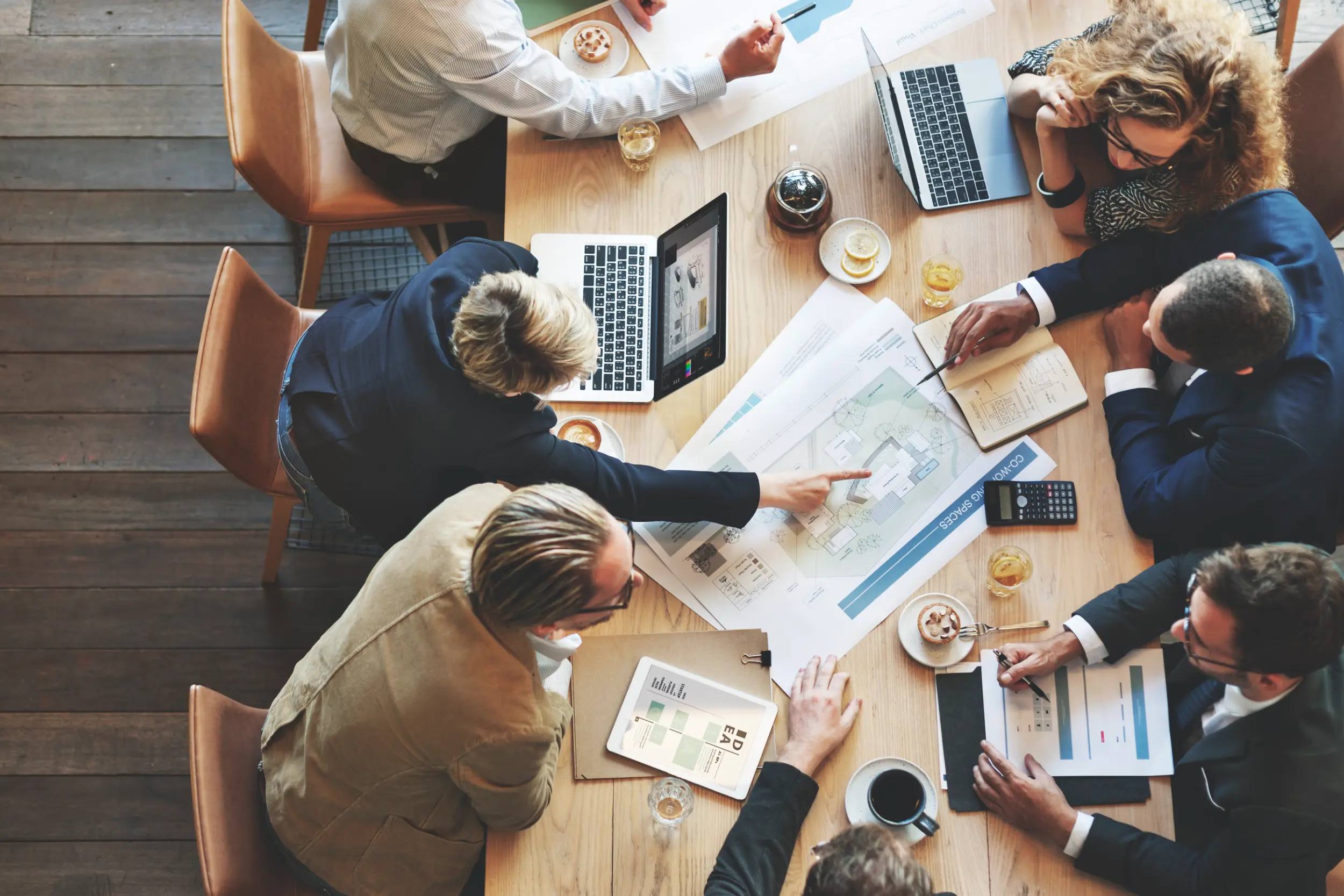 Geschäftspartner sitzen an einem Tisch und diskutieren über Pläne