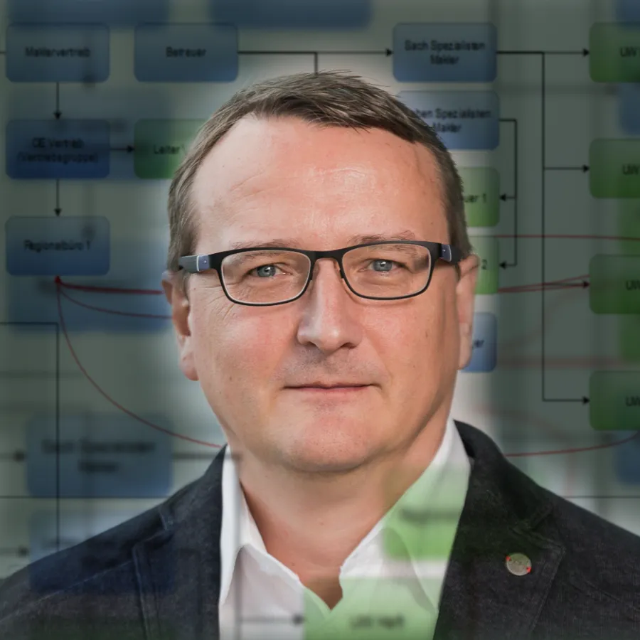 Porträt eines Business-Analysten mit Analysesoftware im Hintergrund.